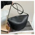 Detail shot of the black leather saddle bag featuring a cute plush bear pendant and strap. - With Pendant / Black