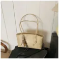 Beige minimalist underarm shoulder bag for women, featuring double straps and cute charm. - White + Pendant
