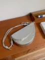 Silver crescent shoulder bag for women, stylish saddle bag with knotted strap design. - Silver