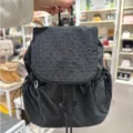 Detail view of the black grid nylon backpack showing texture, drawstring and flap design. - Black Plaid