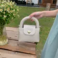 Detailed view of chic beige leather handbag featuring cute heart lock and top handle design. - 20*8*14cm / White Handbag