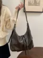 Vista dettagliata della borsa hobo marrone scuro, con morbida pelle PU e spallaccio. - Caffè