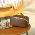 Brown PU leather cosmetic bag with top handle and double zipper for daily travel storage. - 25x12x12cm / Brown