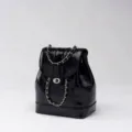 Black glossy leather backpack with metal chain strap, chic flap closure and stylish design. - Black and Silver Chain Backpack