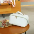 White PU leather cosmetic bag with top handle and double zippers for daily travel storage. - 25x12x12cm / White
