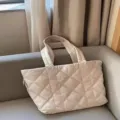 Close-up of a stylish quilted down puffer tote bag with large capacity, ideal for daily commute. - White