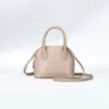 Close-up of stylish beige dome handbag texture, metal zipper and shoulder strap details. - 18x9x15cm / Apricot