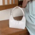 Minimalist white glossy crescent underarm bag soft leather stylish handbag detail view. - White