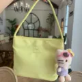 Yellow nylon underarm shoulder bag with embroidery lettering and cute cat plush charm. - Light Yellow