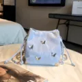 Silver bucket bag with 3D butterflies, drawstring closure, and metal chain strap for women. - Blue