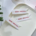 Dettaglio in primo piano di etichette regalo di natale bianche con scritte rosse buon natale. - Lettera Rossa / Confezione da 100