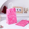 Vista dettagliata della borsa regalo in carta rosa con motivi di cuori e rose per occasioni. - Cuore Rosa / Sacchetti di carta
