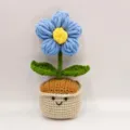 Detailopname van handgemaakte gehaakte pluche bloem in schattige pot, zachte garentextuur. - Blauw
