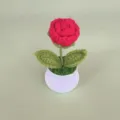 Gedetailleerd uitzicht op een gehaakte rode roos in pot, leuke decoratie voor het bureau. - Rood