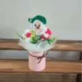 Handgemaakte gehaakte kerstman bloemenboeket in roze emmer, ideaal voor kerstdecoratie en cadeaus. - Kerstman