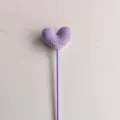 Primo piano dettagliato di uno stelo di fiore di cuore viola all'uncinetto fatto a mano. - Viola chiaro