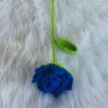 Handgemachte gehäkelte blaue Rose Detailansicht, weiche Garnblume mit grünem Stiel, schöne Deko. - Lila
