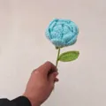Gedetailleerde close-up van een handgemaakte blauwe gehaakte roos met fijne textuur en vakmanschap - Grijs