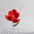 Handmade crochet red tulip flower detail shot, delicate yarn texture and stem design. - Dark Orange