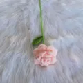 Handgefertigte gehäkelte Rosenblüte Detailansicht, rosa Blume mit grünem Stiel und einzelnem Blatt. - Mode-Rosa