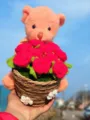 Handcrafted crochet teddy bear holding red rose bouquet in woven basket, exquisite gift detail view. - Red Rose