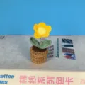 Detailopname van een handgemaakte gehaakte gele margriet in pot als schattige tafeldecoratie. - Geel