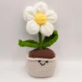 Gros plan détaillé de la fleur bouffante au crochet dans son pot avec un visage souriant. - Blanc