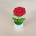Gedetailleerde close-up van een handgemaakte gehaakte rode roos potplant, fijn garen. - Rood