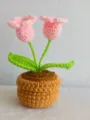 Handmade crochet potted plant detail showing neat yarn stitches and pink flower design. - Pink