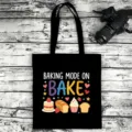 Black canvas tote bag detail featuring baking themed graphic print and sturdy double handles. - Style 17