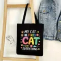 Vista detallada de un bolso tote de lona negra con lindo diseño de gato colorido y texto. - Estilo Gato Dibujos Animados 18
