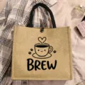 Detailed view of a brown jute tote bag featuring a cute coffee cup print and black handles. - Style 10