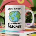 Close-up detail of a white ceramic coffee mug featuring cute globe print and teacher quote. - Style 18 / 350ml