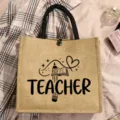 Jute tote bag with teacher letter print and cute pencil book graphic for daily use. - Style 8