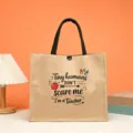 Detail view of a teacher themed jute tote bag with cute print and sturdy handles. - Tiny humans DON'T scare me I'm a teacher Variation