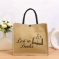 Nahaufnahme der Vintage Jute-Tragetasche mit niedlichem Buch-Grafikdruck und robusten Griffen. - Botanischer Druck Stil Dreizehn