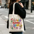 Detailansicht der cremeweißen Canvas-Tragetasche mit buntem Blumenladen-Cartoon-Druck. - Blumenladen Druck