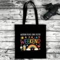 Detailed close-up shot of a black canvas tote bag featuring a vibrant weekend graphic print. - Style 10