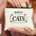 Primer plano detallado de bolsa cosmetica de lona blanca con letras de gatos y brocha. - Estilo de Estampado Gatos Ovillo de Lana