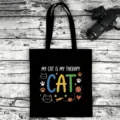 Detailed view of black canvas tote bag featuring cute cat themed graphic print and text. - Style 06