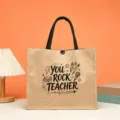 Teacher appreciation burlap tote bag detail shot showing custom printed design and durable fabric. - YOU ROCK TEACHER