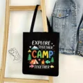 Detalle de la escena del bolso tote de lona negra con estampado de camping y fondo de mezclilla. - Estilo Camping 05