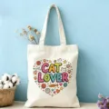 Vue rapprochée du sac cabas en toile écru avec un joli imprimé coloré de cœur d'amoureux des chats. - Thème Chat (01)