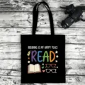 Black canvas tote bag with colorful reading theme print, ideal for teachers and book lovers. - Style 02