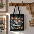Detailed shot of a black canvas tote bag with colorful math print hanging on a wall hook. - Style 3 / Black