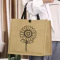 Detail view of the retro jute tote bag featuring a charming black sunflower illustration. - Sunflower Style (2)