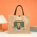 Close-up detail of the cute teacher cartoon print jute tote bag on a warm orange background. - Style 5