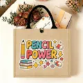 Close-up of jute tote bag featuring colorful pencil power print, black handles, and gift decor scene. - Pencil Power Style (14)