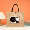 Detail view of the retro music print jute tote bag with black handles and snap closure. - Vinyl Record Style (2)