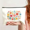 Detailansicht der weißen Canvas-Kosmetiktasche mit farbiger Blumenstickerei und Reißverschluss. - Stil 10
